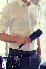 Image showing close up of male stylist with brush at salon