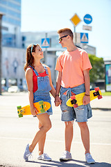 Image showing teenage couple with skateboards on city street