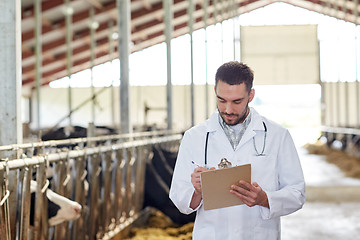 Image showing veterinarian with cows in cowshed on dairy farm