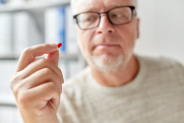 Image showing close up of old man hand with pill