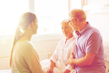 Image showing happy family visiting senior woman at hospital