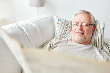 Image showing close up of senior man reading newspaper at home