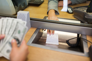 Image showing bank clerk giving receipt to customer with money