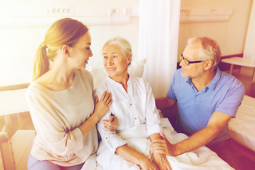 Image showing happy family visiting senior woman at hospital