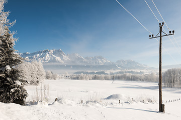 Image showing Austrian Winter Wonderland with mountains, a power pole, fresh snow and haze