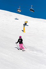 Image showing Female skier in fresh powder snow and blue sky