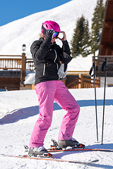 Image showing Female skier getting dressed in front of skiing hut