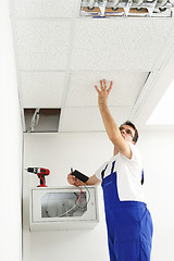 Image showing Professional handy man worker mounts ceiling .