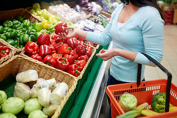 Image showing woman with basket buying peppers at grocery store