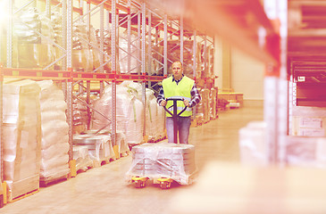 Image showing man carrying loader with goods at warehouse