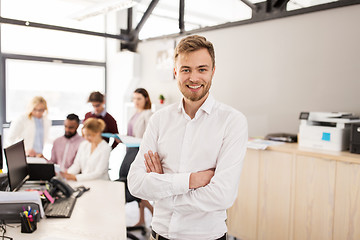 Image showing happy young man over creative team in office