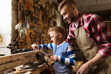 Image showing father and son with rasp working at workshop