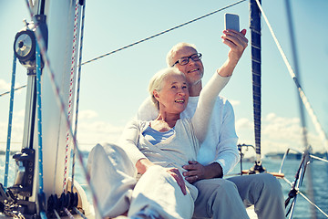 Image showing seniors with smartphone taking selfie on yacht
