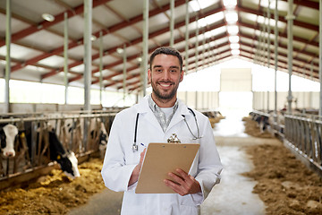 Image showing veterinarian with cows in cowshed on dairy farm