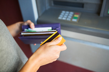 Image showing hands with money and credit card at atm machine