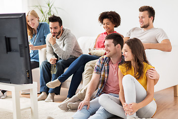 Image showing happy friends with popcorn watching tv at home