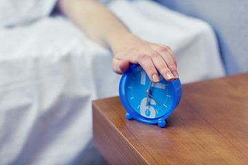 Image showing close up of hand on alarm clock in bedroom