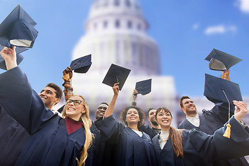 Image showing happy students or bachelors waving mortar boards