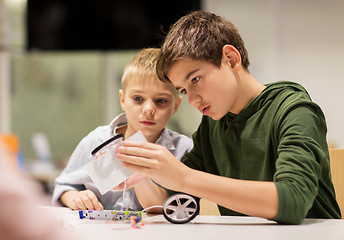 Image showing happy children building robots at robotics school