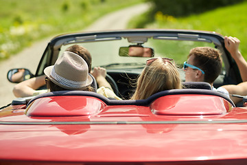 Image showing happy friends driving in convertible car at summer