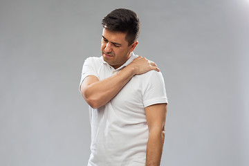 Image showing unhappy man suffering from pain in shoulder