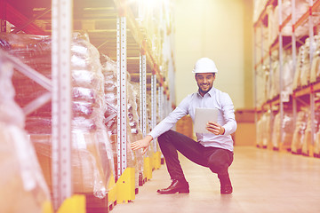 Image showing happy businessman with tablet pc at warehouse