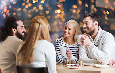 Image showing happy friends drinking tea at cafe