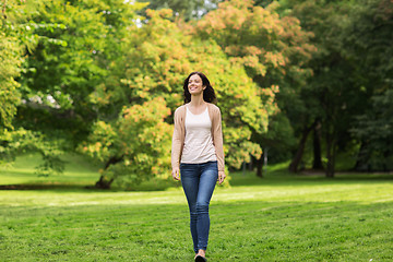 Image showing beautiful happy young woman walking in summer park