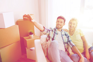 Image showing couple with boxes moving to new home and dreaming