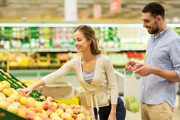 Image showing happy couple buying apples at grocery store