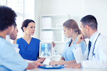 Image showing group of doctors with x-ray on tablet pc at clinic