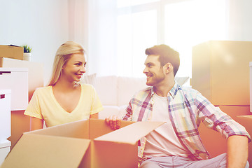 Image showing smiling couple with many boxes moving to new home