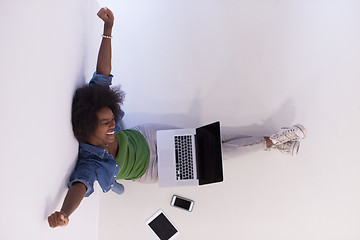 Image showing african american woman sitting on floor with laptop top view