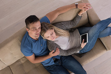 Image showing youg couple in living room with tablet top view