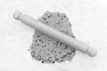 Image showing Cookie dough being rolled out with a wooden rolling pin