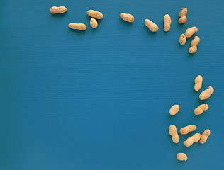 Image showing Monkey nuts scattered on a blue painted background