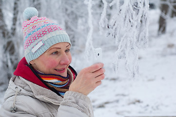 Image showing Woman photographing on mobile phone in winter park