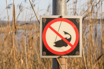 Image showing No fishing sign on a post by a river