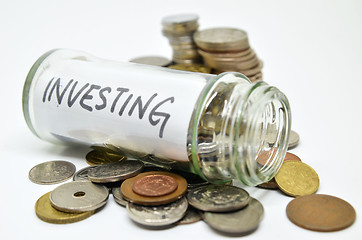 Image showing Investment lable in a glass jar with coins spilling out