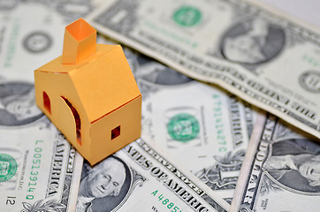 Image showing Miniature paper made house stand on  money