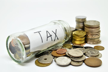 Image showing Tax lable in a glass jar with coins spilling out