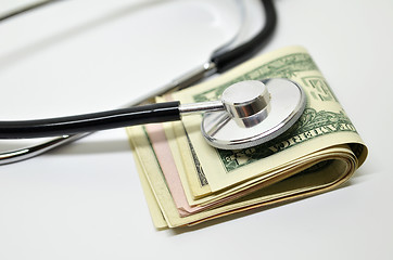 Image showing Stethoscope sitting on US dollar bills