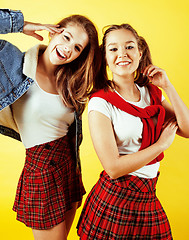 Image showing lifestyle people concept: two pretty school girl having fun on yellow background, happy smiling students 