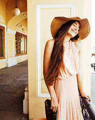 Image showing young pretty smiling woman in hat with bags on shopping at store