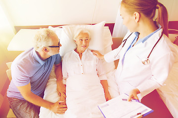 Image showing senior woman and doctor with clipboard at hospital