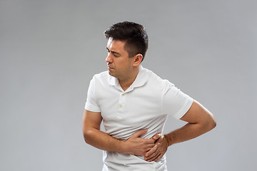 Image showing unhappy man suffering from stomach ache