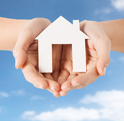 Image showing close up of hands holding paper house