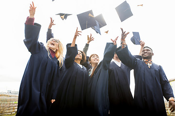 Image showing happy students throwing mortar boards up