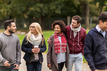 Image showing happy friends walking along autumn park