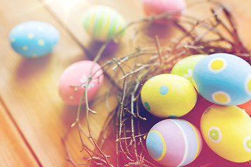 Image showing close up of colored easter eggs in nest on wood